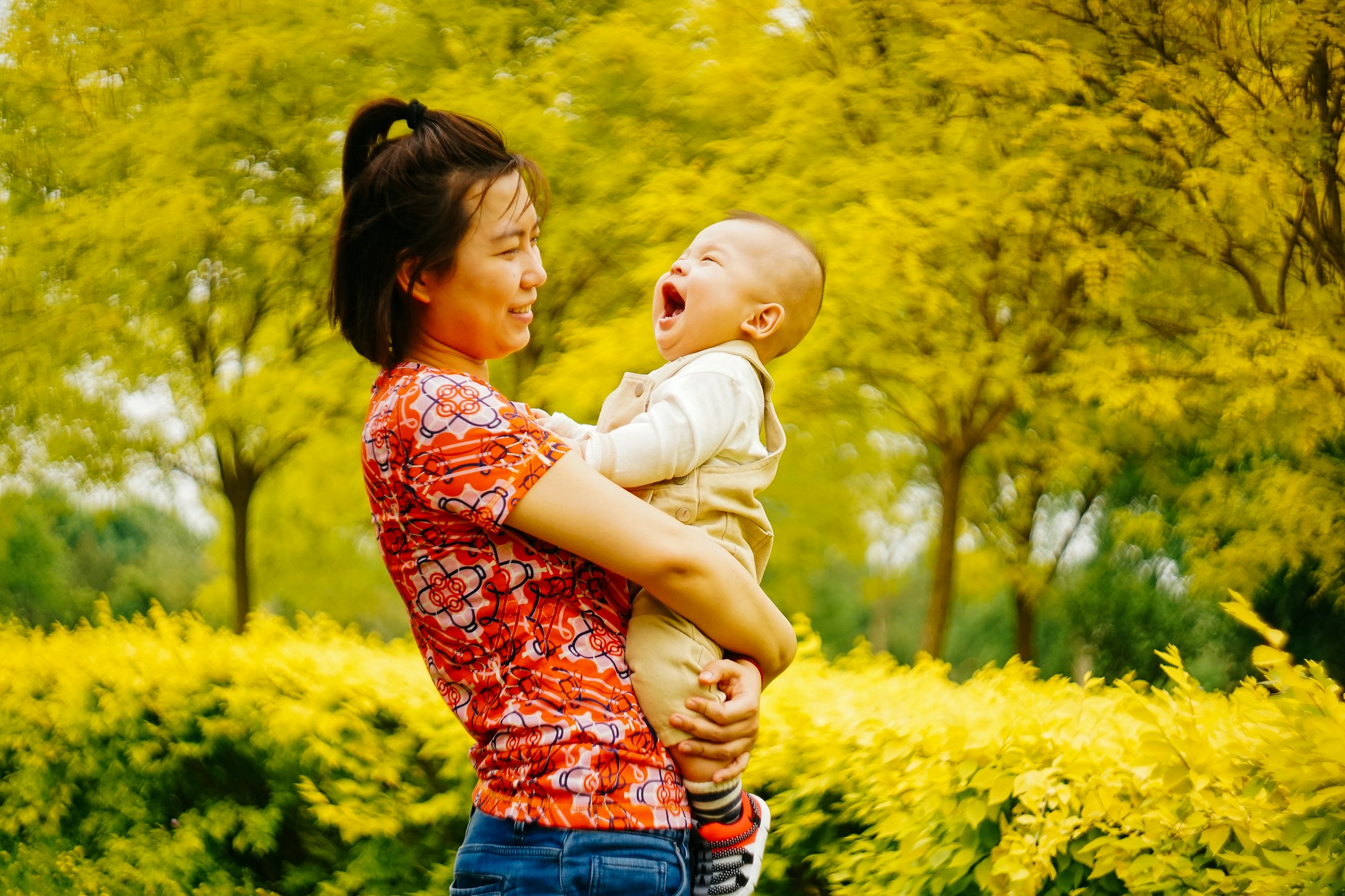 Mother carrying her baby outdoors